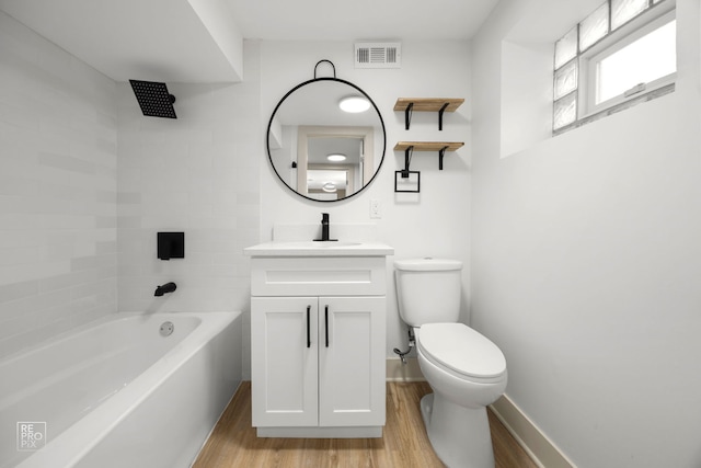 full bathroom featuring toilet, vanity, wood finished floors, baseboards, and visible vents