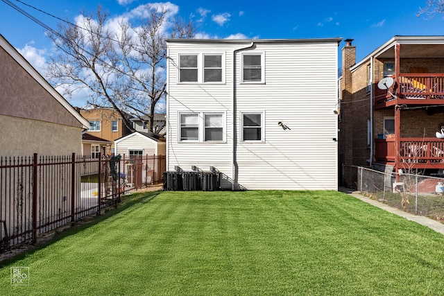 rear view of property featuring a fenced backyard and a lawn