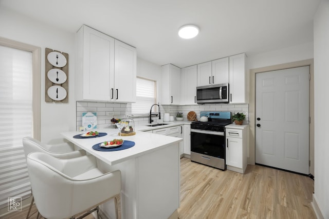 kitchen with light countertops, white cabinets, and stainless steel appliances