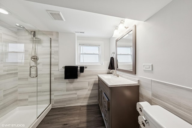 6317 W Roscoe St, Chicago, IL 60634 - full bathroom featuring tile walls, a stall shower, vanity, and wainscoting