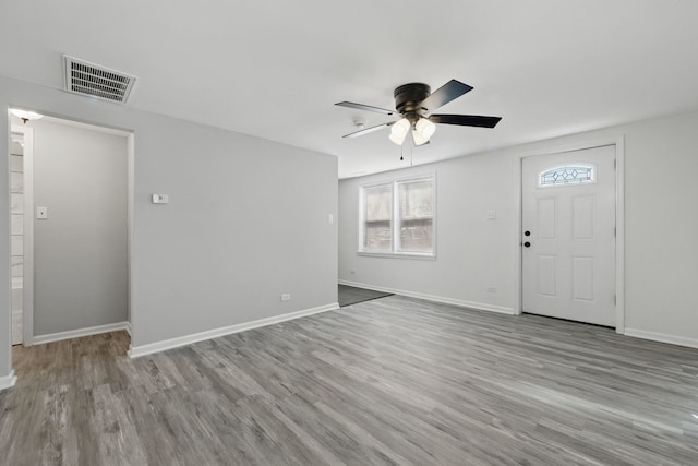 entryway with baseboards, visible vents, a ceiling fan, and wood finished floors