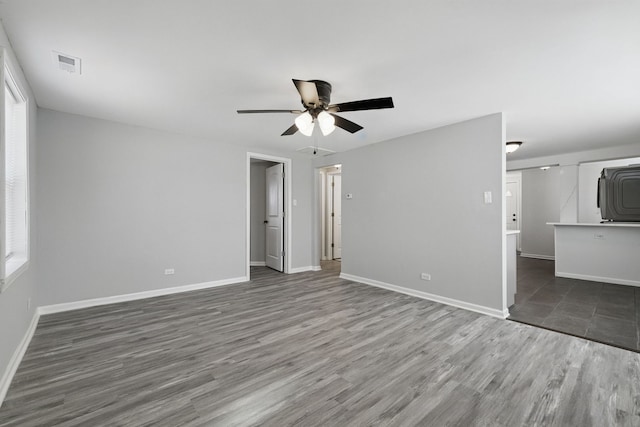 unfurnished living room with baseboards, wood finished floors, and ceiling fan