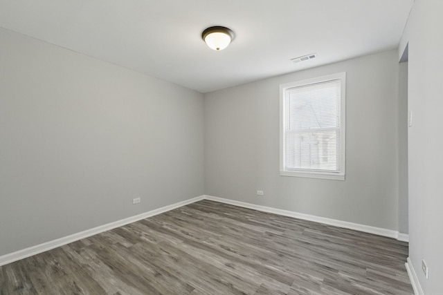 spare room with dark wood finished floors, baseboards, and visible vents