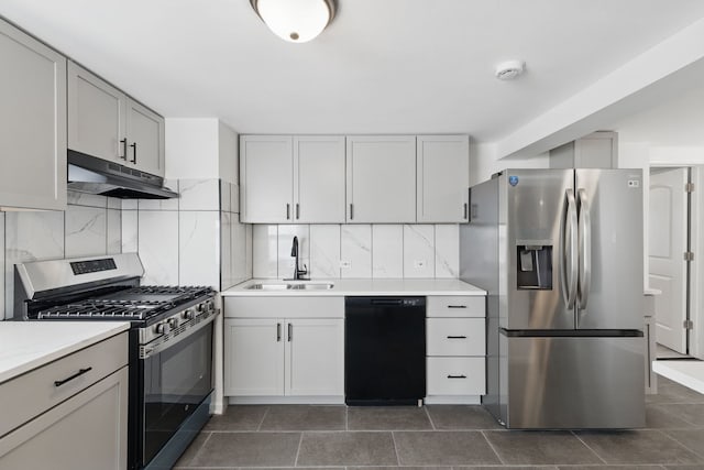 kitchen with backsplash, a sink, appliances with stainless steel finishes, and under cabinet range hood