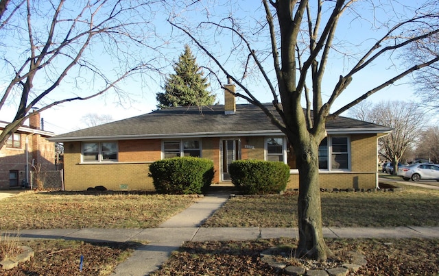single story home with a chimney and brick siding