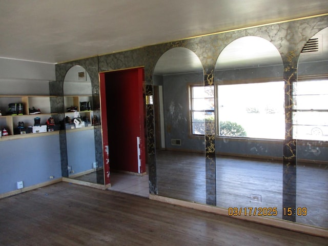 interior space featuring visible vents, arched walkways, and wood finished floors