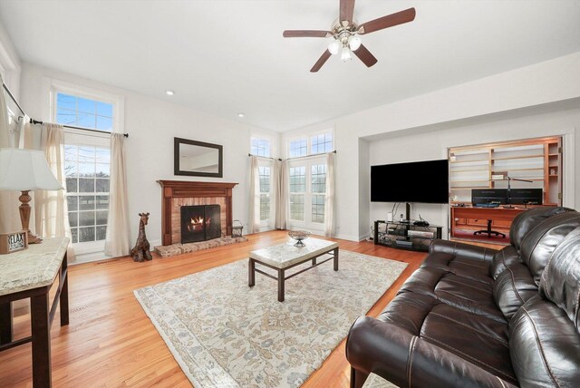 living area featuring a wealth of natural light, ceiling fan, and wood finished floors