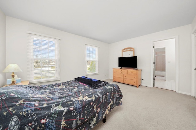 bedroom featuring carpet floors, ensuite bath, and baseboards