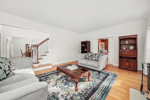living room featuring stairway, an inviting chandelier, ornamental molding, baseboards, and light wood-style flooring