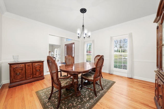 dining area with ornamental molding, baseboards, light wood-style floors, and a chandelier