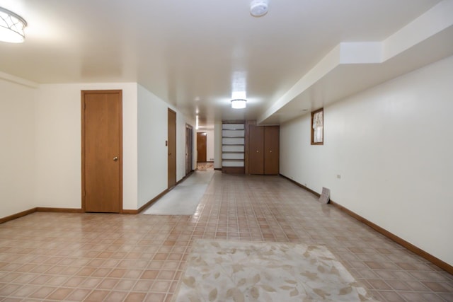 spare room with baseboards and light tile patterned flooring