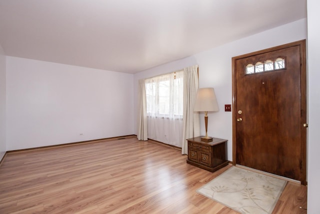 foyer entrance with baseboards and light wood-type flooring