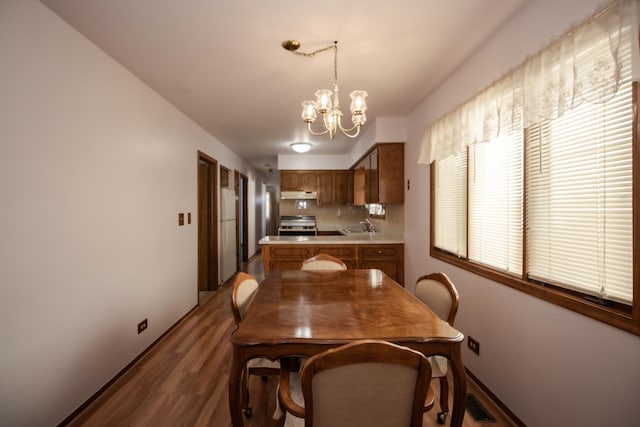 dining room featuring baseboards, visible vents, a chandelier, and wood finished floors