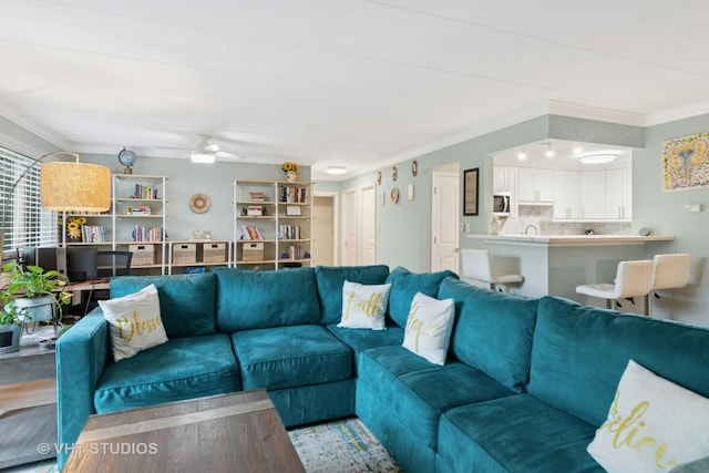 living room with crown molding and ceiling fan