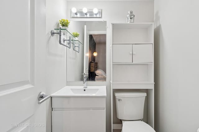 half bathroom with vanity and toilet