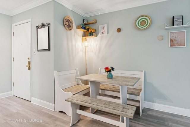 dining space with baseboards, ornamental molding, and wood finished floors