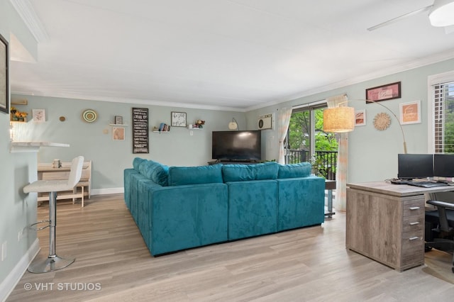living area with baseboards, ornamental molding, a wealth of natural light, and light wood-style flooring
