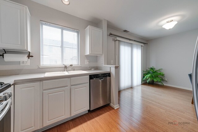 4553 W Hill Ave Unit 3, Waukegan, IL 60085 - kitchen with dishwasher, a sink, plenty of natural light, white cabinets, and recessed lighting
