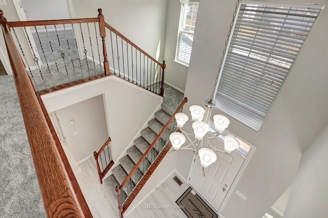 stairs with a chandelier and baseboards