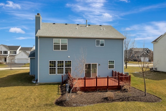 back of house featuring a deck, a chimney, a yard, roof with shingles, and a residential view