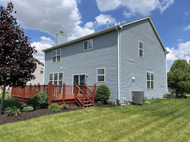 back of property with a chimney, central air condition unit, a wooden deck, and a yard