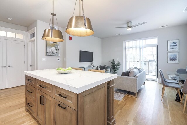 514 Hillgrove Ave Unit 204, Western Springs, IL 60558 - kitchen featuring decorative light fixtures, a center island, light wood finished floors, ceiling fan, and brown cabinetry