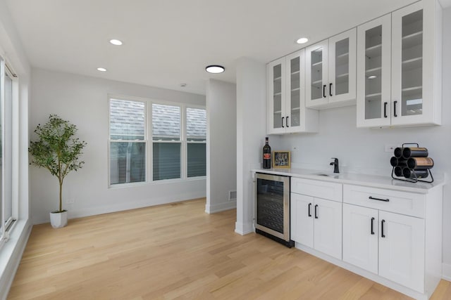1522 W Wolfram St, Chicago, IL 60657 - bar with beverage cooler, wet bar, baseboards, and light wood-style floors