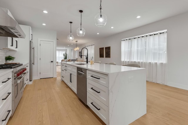 1522 W Wolfram St, Chicago, IL 60657 - kitchen featuring a kitchen island with sink, recessed lighting, a sink, appliances with stainless steel finishes, and exhaust hood