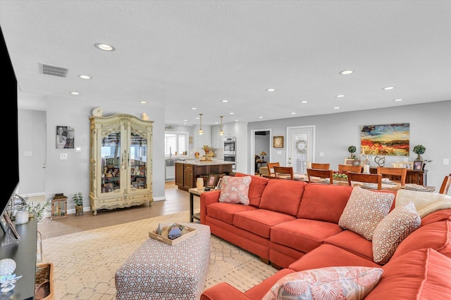 living room with light tile patterned flooring, baseboards, visible vents, and recessed lighting