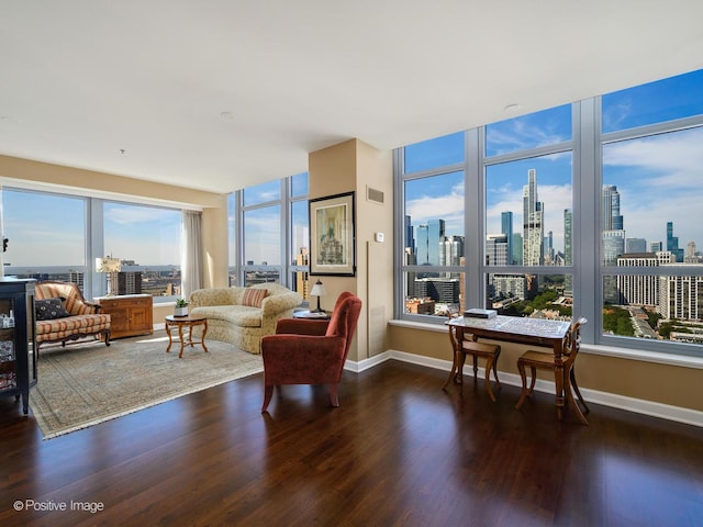living room featuring baseboards, visible vents, wood finished floors, and a city view