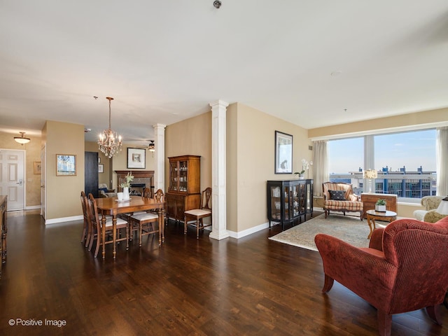 dining space featuring ornate columns, baseboards, and wood finished floors