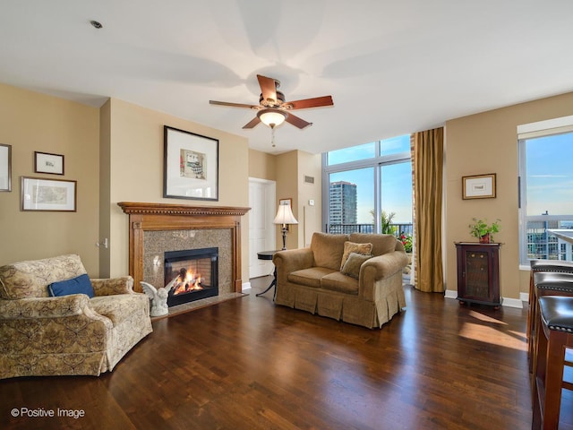 living room with a high end fireplace, plenty of natural light, ceiling fan, and wood finished floors