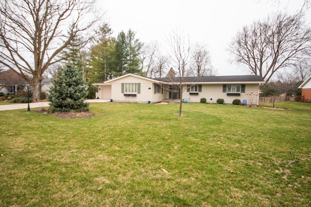 view of front of property featuring fence, concrete driveway, and a front yard
