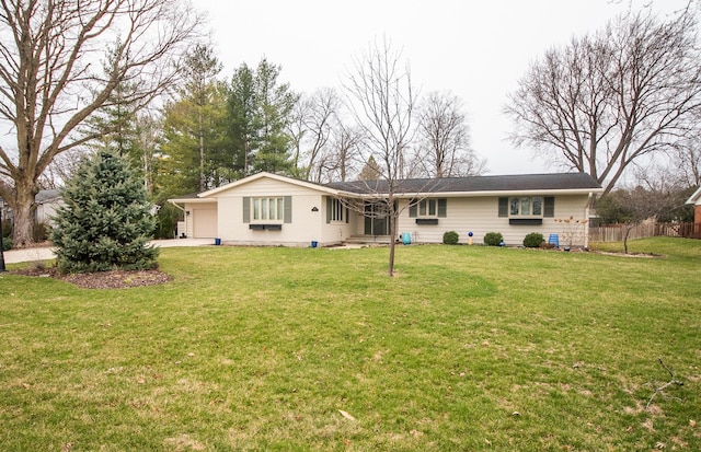 back of house with concrete driveway, an attached garage, fence, crawl space, and a yard