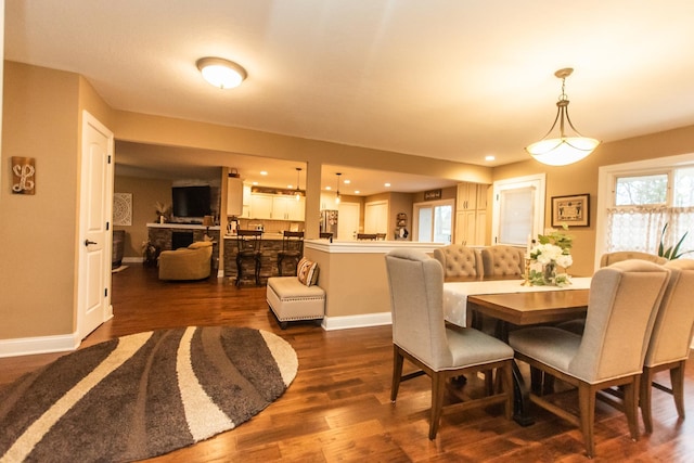 dining space featuring dark wood-type flooring, baseboards, and recessed lighting