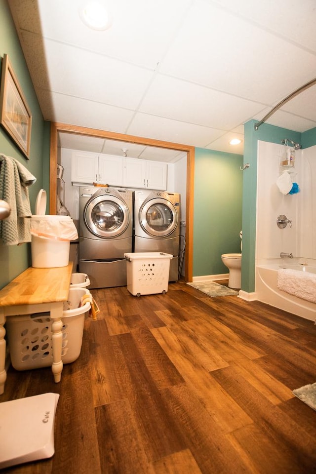 laundry room with independent washer and dryer, cabinet space, baseboards, and wood finished floors