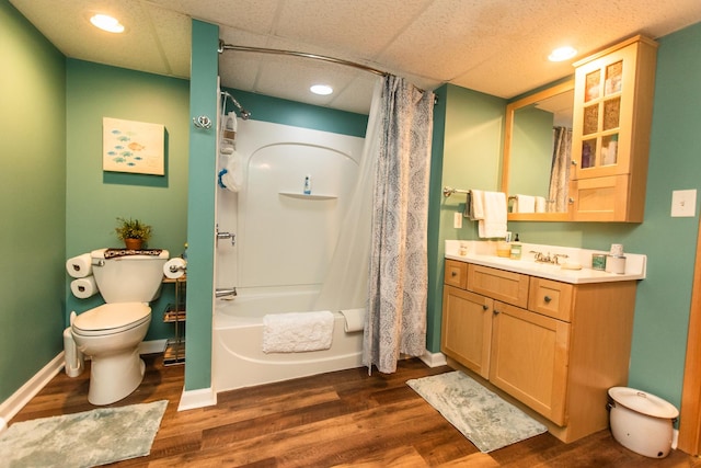 full bath featuring baseboards, wood finished floors, toilet, vanity, and shower / tub combo