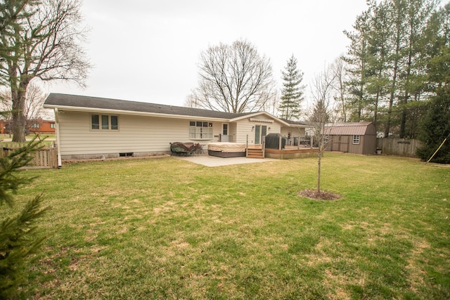 back of property featuring an outbuilding, a deck, fence, a storage unit, and a yard