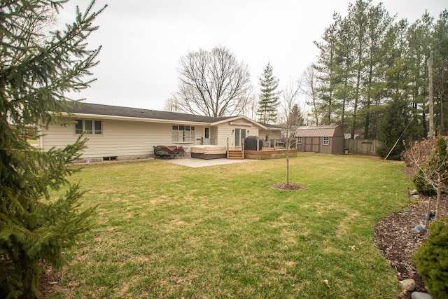 back of house with a patio area, a shed, a deck, an outdoor structure, and a yard
