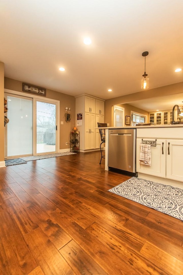 kitchen with white cabinetry, hanging light fixtures, dark wood-style floors, and stainless steel dishwasher