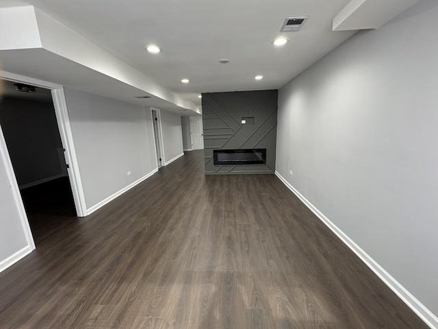 unfurnished living room featuring dark wood-style floors, visible vents, recessed lighting, and baseboards