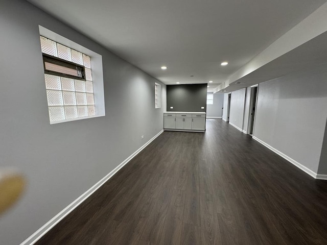 empty room with dark wood-style floors, baseboards, and recessed lighting