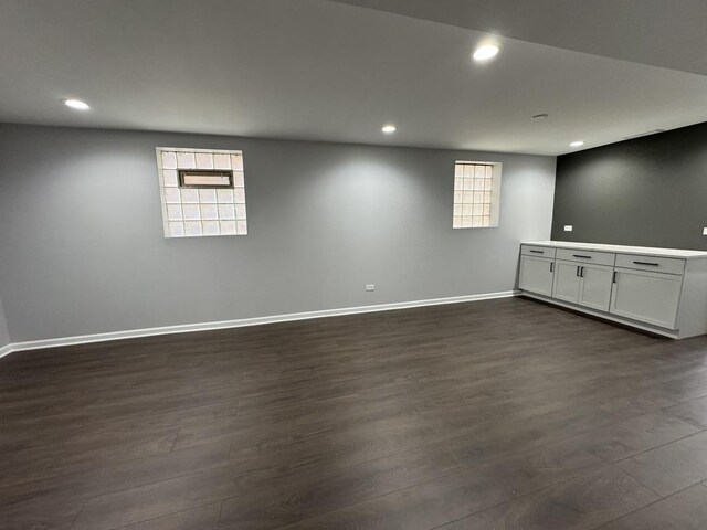 below grade area featuring baseboards, dark wood-style floors, and recessed lighting