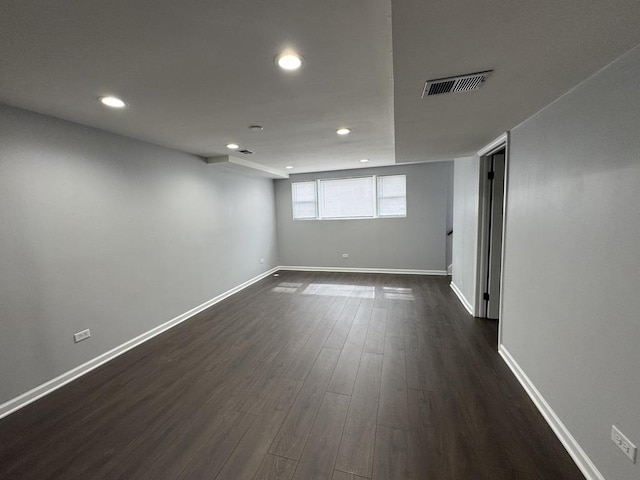 spare room with recessed lighting, dark wood-style floors, baseboards, and visible vents