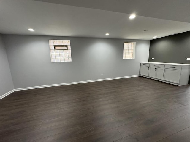 below grade area featuring recessed lighting, baseboards, and dark wood finished floors