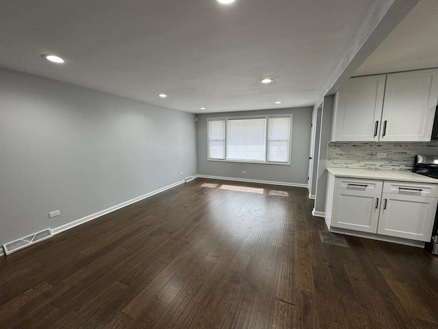 interior space featuring baseboards, dark wood-style flooring, visible vents, and recessed lighting