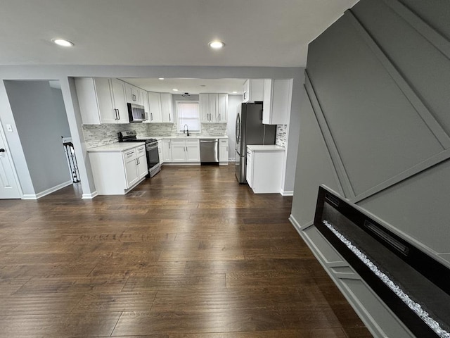 kitchen with dark wood finished floors, light countertops, a sink, and stainless steel appliances