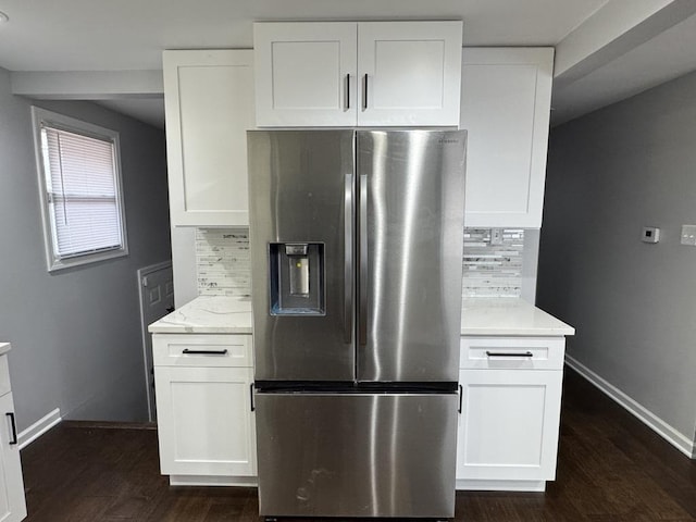 kitchen featuring dark wood finished floors, stainless steel fridge with ice dispenser, baseboards, and decorative backsplash