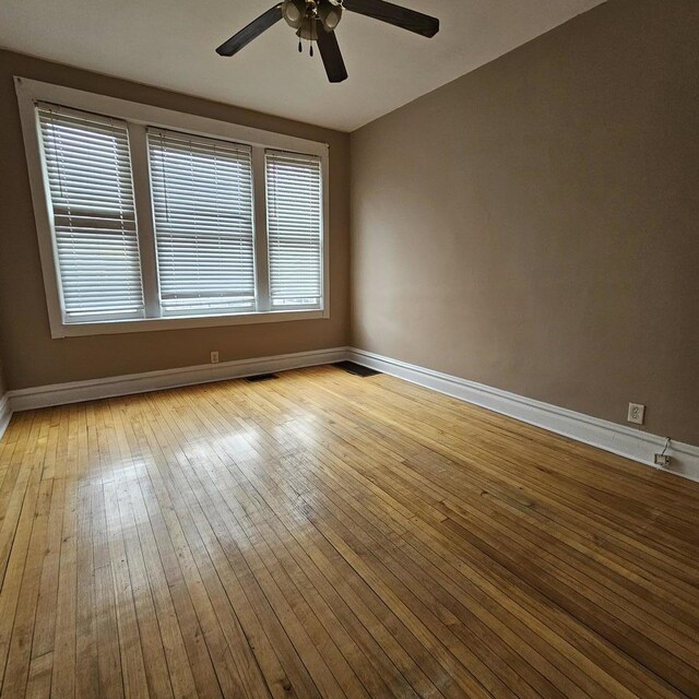 2251 S Kirkland Ave, Chicago, IL 60623 - unfurnished room with hardwood / wood-style floors, visible vents, baseboards, and a ceiling fan
