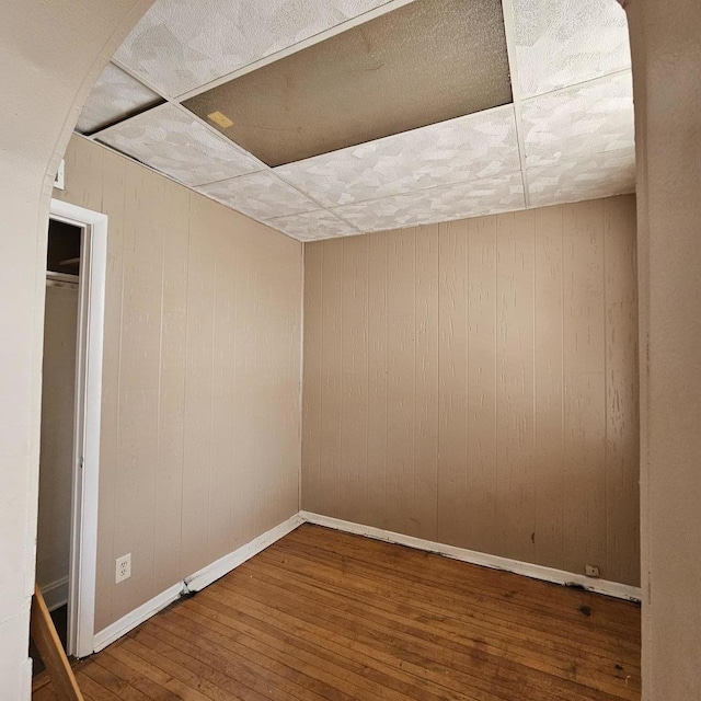 2251 S Kirkland Ave, Chicago, IL 60623 - unfurnished bedroom with baseboards, wooden walls, and hardwood / wood-style floors